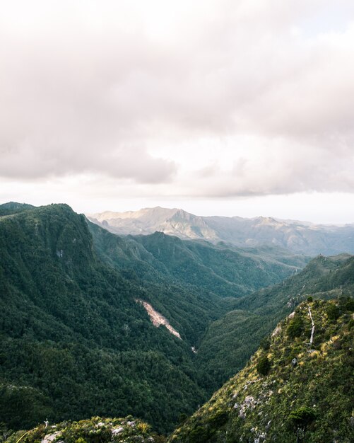 Bela foto de montanhas e colinas verdes rochosas e céu nublado incrível durante o pôr do sol