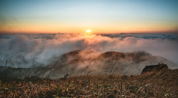 Bela foto de montanhas sob um céu nublado ao pôr do sol