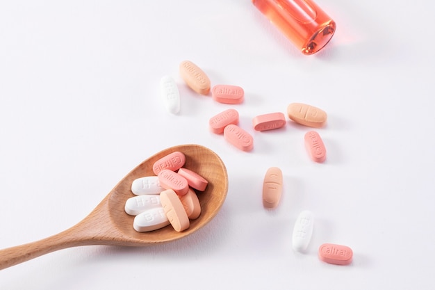 Bela foto de muitos comprimidos de cálcio Caltrate em uma colher de pau