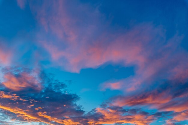 Bela foto de nuvens cor de rosa em um céu azul claro com um cenário do nascer do sol