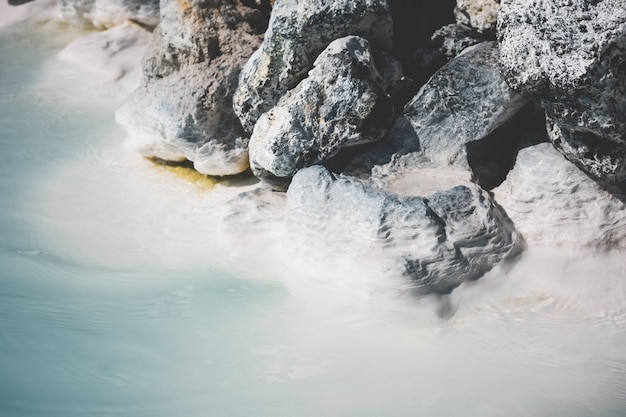 Bela foto de pedras empilhadas perto de uma água cristalina