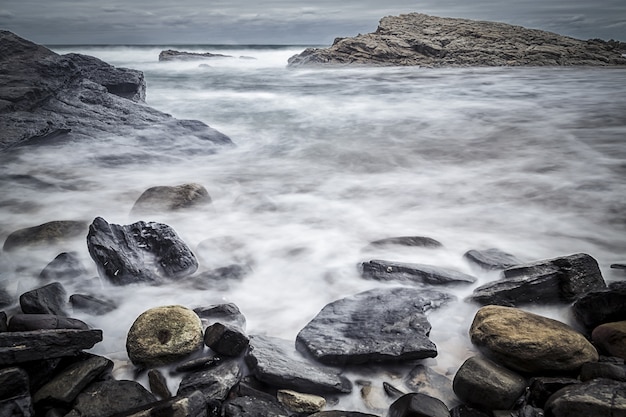 Foto grátis bela foto de pedras na praia com um céu sombrio