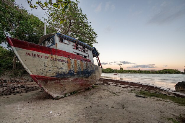 Bela foto de um barco abandonado deixado na costa