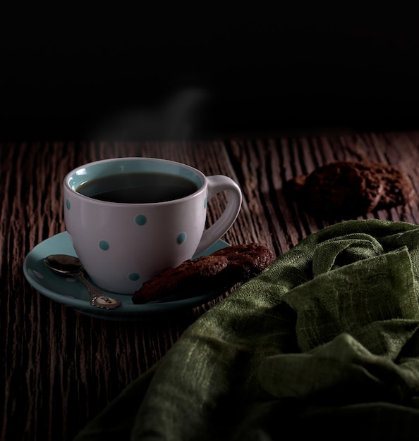 Bela foto de um café quente com um delicioso par de biscoitos com um fundo desfocado