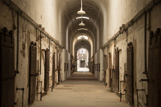 Bela foto de um corredor em forma de arco em um antigo prédio abandonado com muitas portas