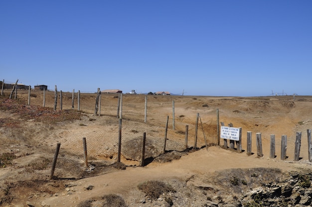 Bela foto de um deserto no Chile separado por uma cerca com prédios ao fundo