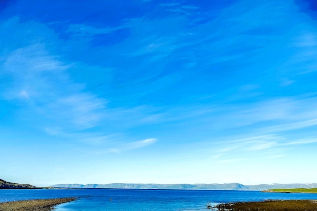 Bela foto de um mar com montanhas à distância sob um céu azul