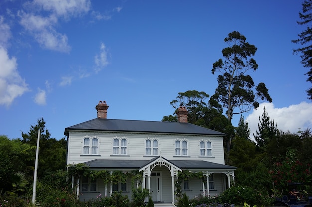 Bela foto de um prédio branco em Hamilton Gardens, Nova Zelândia, sob um céu azul