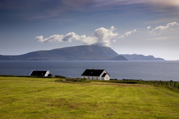 Bela foto de uma casa isolada em um vale próximo ao mar do Condado de Mayo, na Irlanda