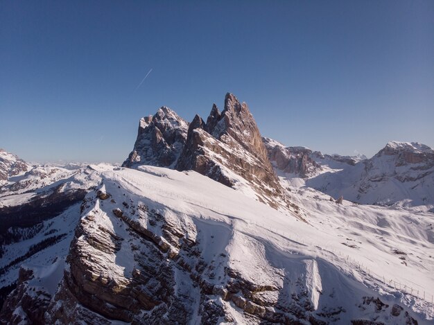 Bela foto de uma montanha íngreme coberta de neve branca durante o inverno