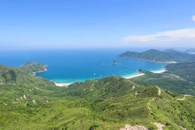 Bela foto de uma paisagem de colinas arborizadas e um oceano azul