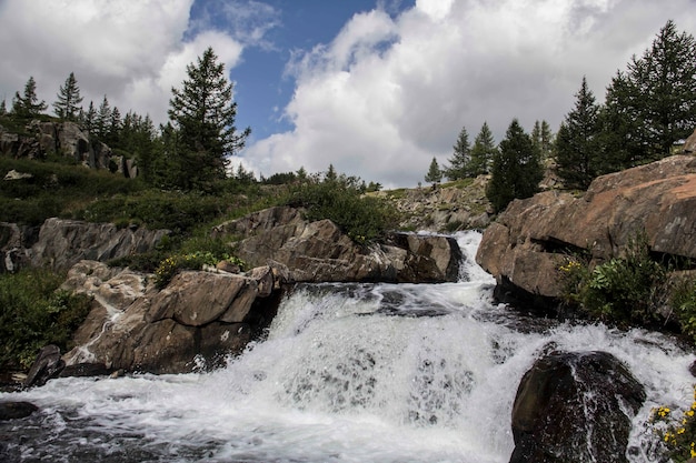 Foto grátis bela foto de uma pequena cachoeira com formações rochosas e árvores ao redor em um dia nublado
