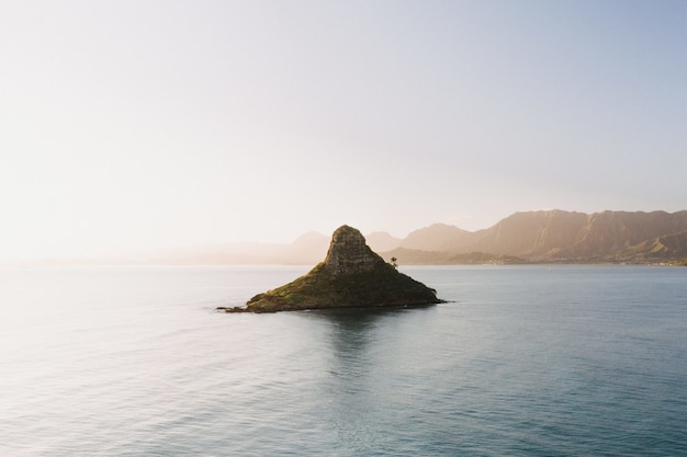 Foto grátis bela foto de uma pequena ilha no centro do mar aberto com um cenário do nascer do sol