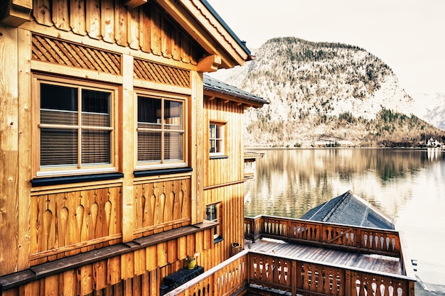 Bela foto de uma pequena vila cercada por um lago e colinas nevadas