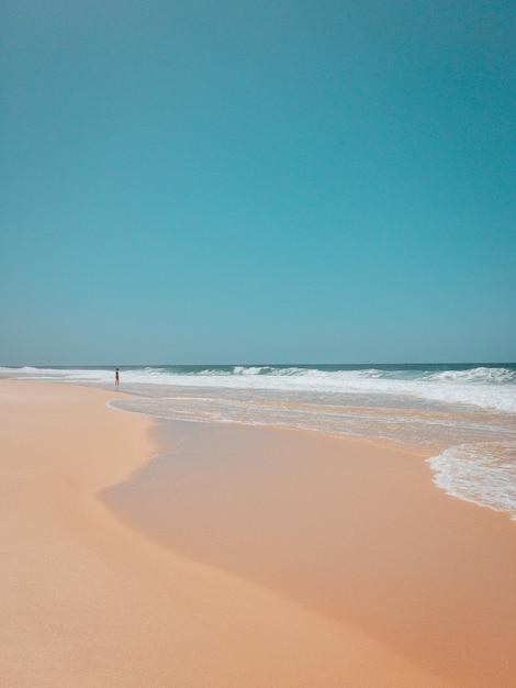 Bela foto de uma praia de areia no rio de janeiro com ondas fortes do oceano