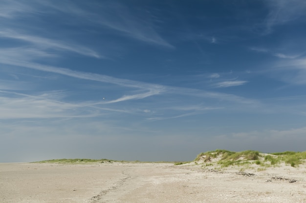 Bela foto de uma praia de areia sob um céu azul claro