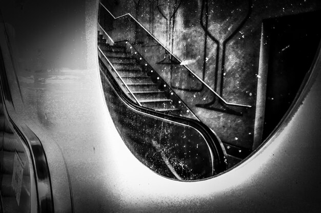 Bela foto em tons de cinza do reflexo de uma escada em um espelho na parede
