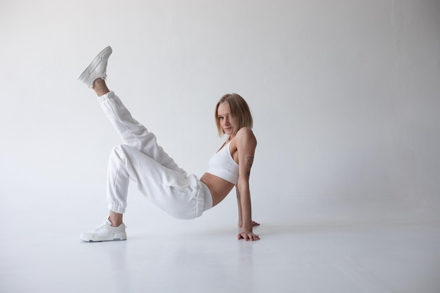 Foto grátis bela garota loira com top branco e meias posando em um fundo branco