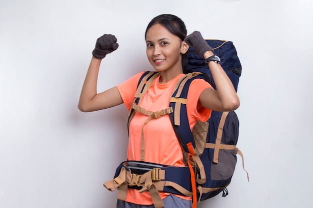 Bela jovem alpinista asiática com uma mochila fazendo gestos fortes, isolado no fundo branco