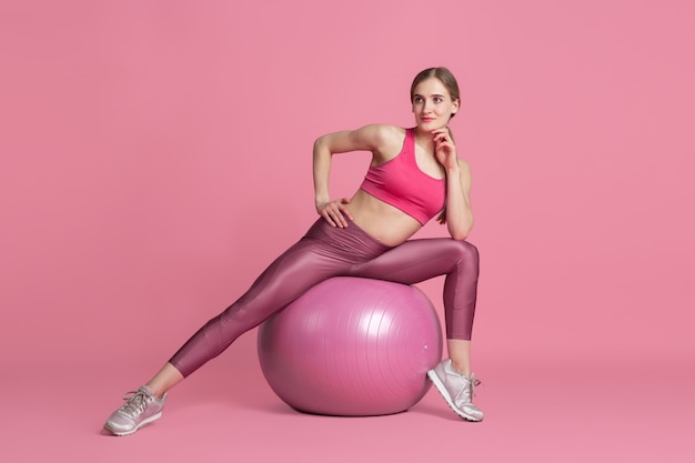 Foto grátis bela jovem atleta praticando no retrato monocromático de parede rosa