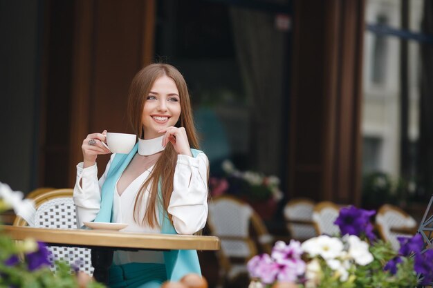 bela jovem com café no restaurante