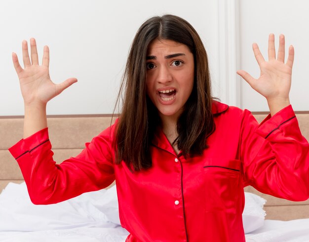 Foto grátis bela jovem de pijama vermelho relaxando na cama