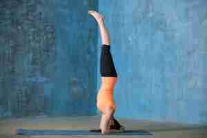 Foto grátis bela jovem esportiva fazendo headstand