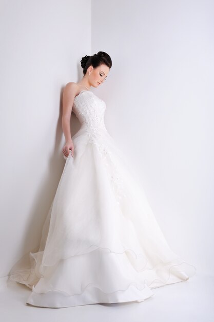 Bela jovem noiva com um elegante vestido de noiva branco