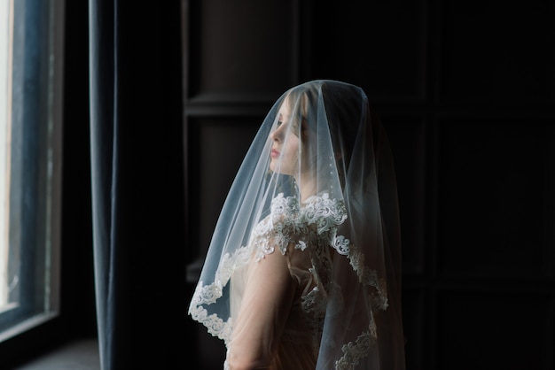 Bela jovem noiva em uma lingerie branca. últimos preparativos para o casamento. a menina está esperando o noivo.