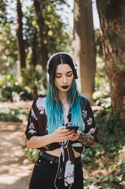 Bela jovem ouvindo música no fone de ouvido através do celular