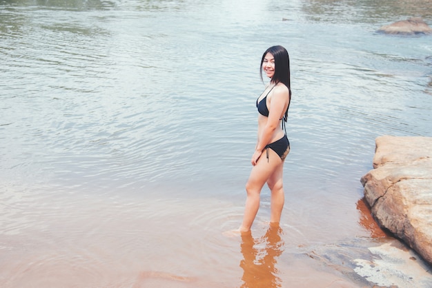 Bela jovem sexy em bikini na localização do Rio de montanha