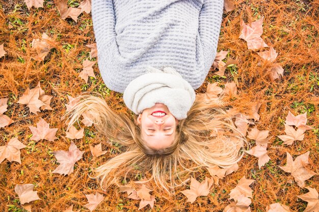 Bela modelo feminino deitado na grama de outono