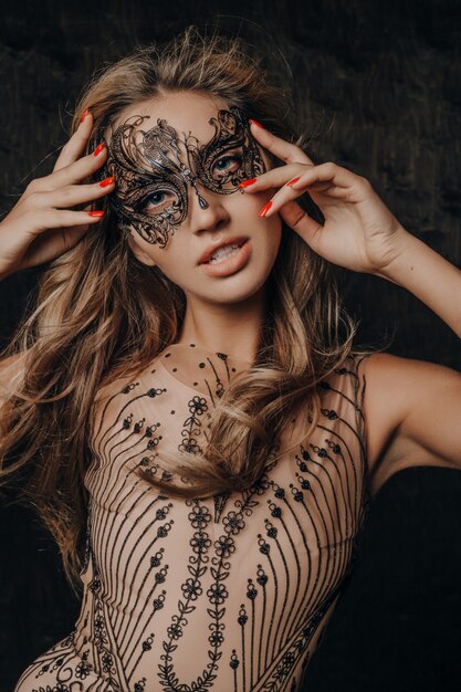 Bela modelo sexy mulher com vestido de noite de renda luxuosa posando com máscara de carnaval