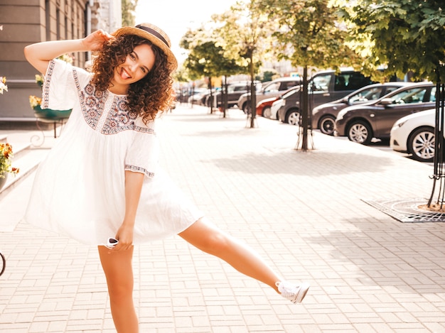 Foto grátis bela modelo sorridente com afro cachos penteado vestido com vestido branco hipster de verão.