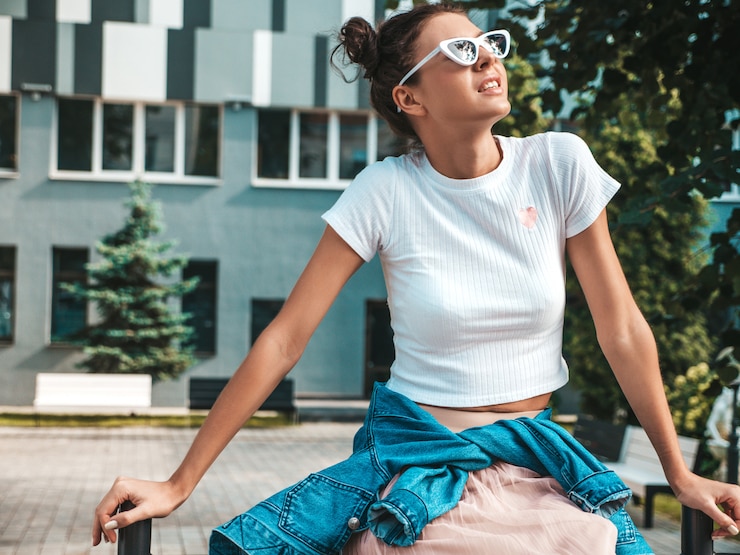 Foto grátis bela modelo sorridente com penteado de chifres, vestido com roupas de jeans de jaqueta hipster de verão. garota despreocupada sexy, posando na rua. mulher na moda engraçada e positiva, se divertindo em óculos de sol