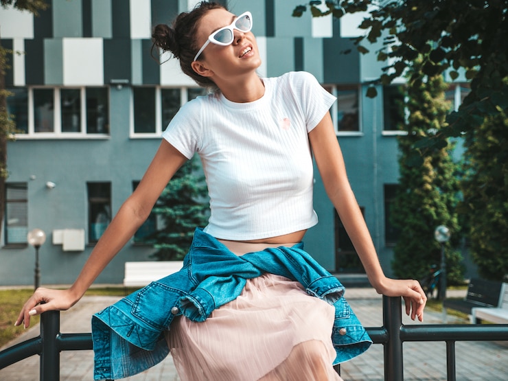 Foto grátis bela modelo sorridente com penteado de chifres, vestido com roupas de jeans de jaqueta hipster de verão. garota despreocupada sexy, posando na rua. mulher na moda engraçada e positiva, se divertindo em óculos de sol