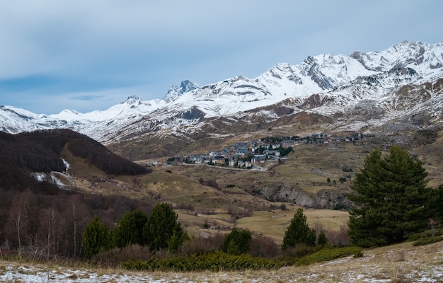 Bela montanha rochosa coberta de neve sob um céu nublado