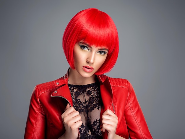 Bela mulher sexy com penteado bob vermelho brilhante. Modelo de moda. Garota sensual e linda em uma jaqueta de couro. Rosto deslumbrante de uma senhora bonita.