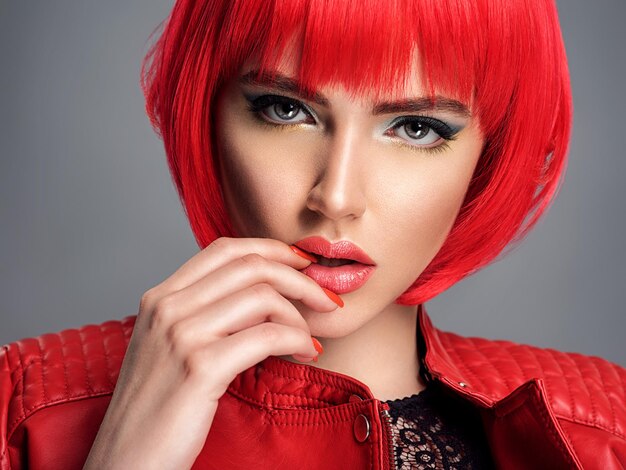 Bela mulher sexy com penteado bob vermelho brilhante. Modelo de moda. Garota sensual e linda em uma jaqueta de couro. Rosto deslumbrante de uma senhora bonita.