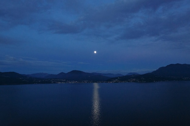 Bela noite terrascape. Caminho lunar no lago e na montanha