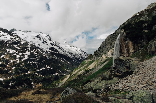 Bela paisagem alpina com cascata na montanha no horário de verão