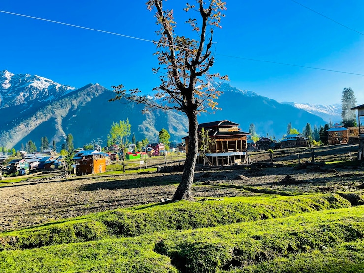 Foto grátis bela paisagem de arang kel, na caxemira, com campos verdes e casas locais escondidas nas nuvens.