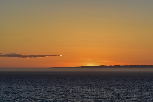 Bela paisagem de mar tranquilo com um pôr do sol de tirar o fôlego ao fundo