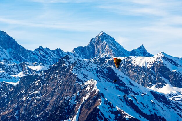 Bela paisagem de montanhas cobertas de neve com um parapente no Tirol do Sul, Dolomitas, Itália