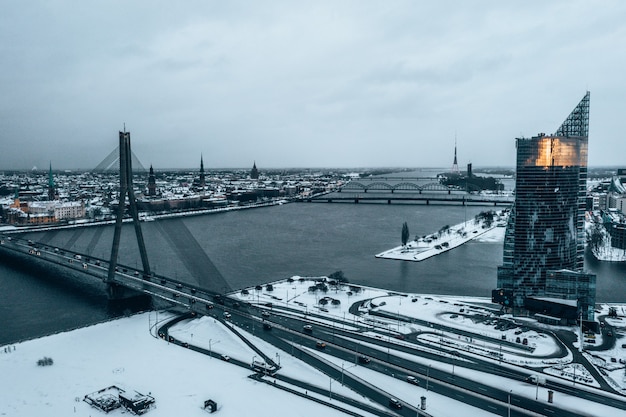 Bela paisagem nevada de Riga vista através da ponte Vansu