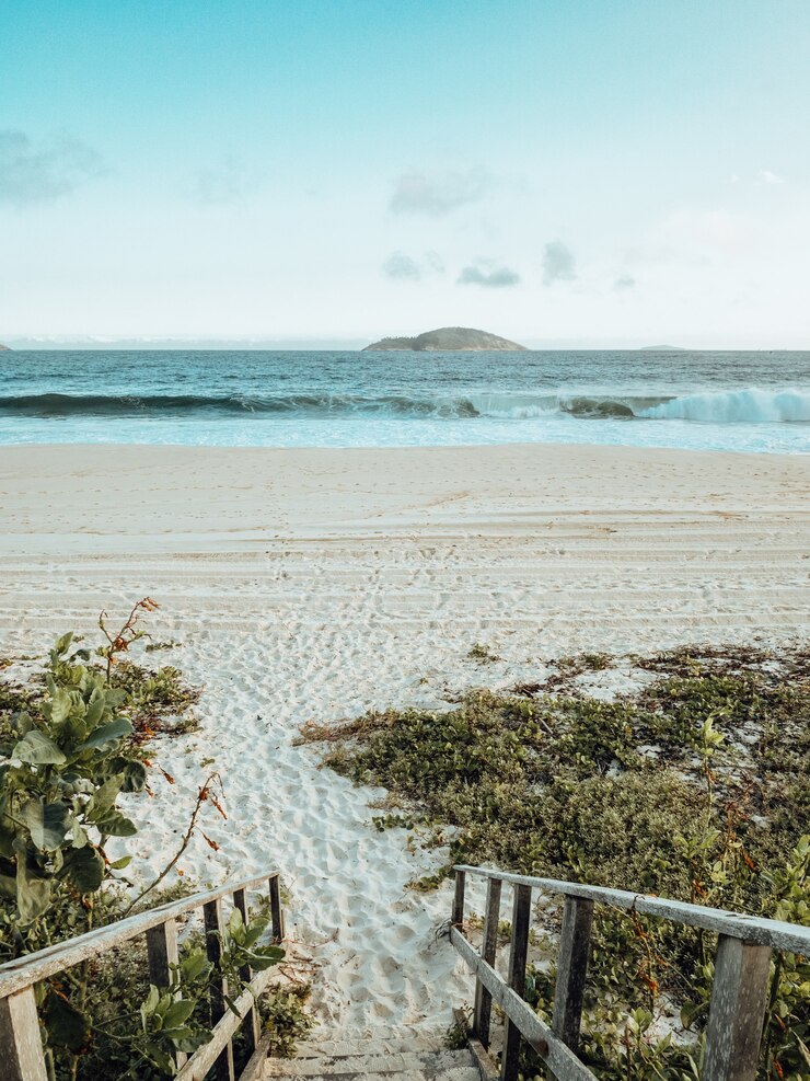 Foto grátis bela paisagem vista do mar na praia do rio de janeiro durante o pôr do sol com ondas quebrando