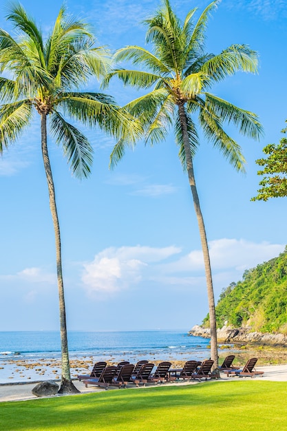 Bela palmeira de coco tropical com cadeira ao redor do oceano, praia, oceano, com nuvem branca no céu azul