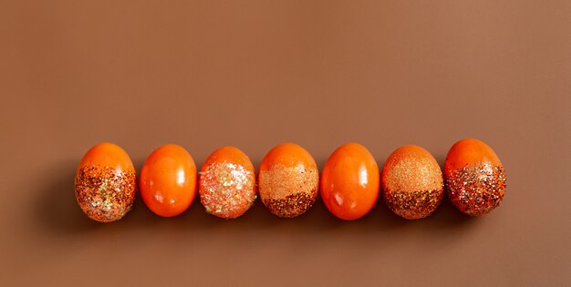 Bela Páscoa com ovos decorativos laranja em lantejoulas.