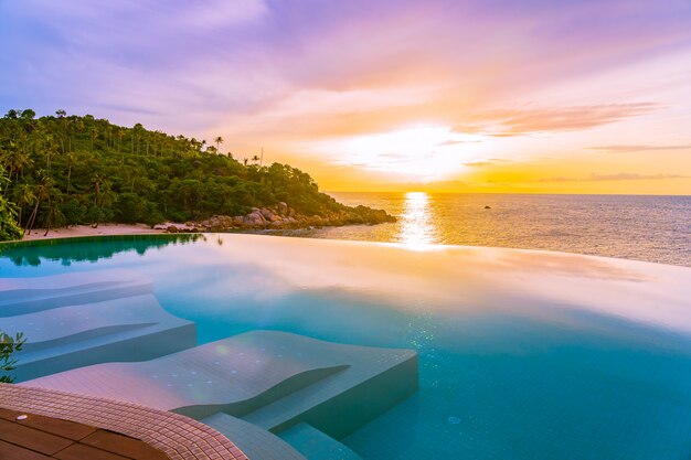 Bela piscina ao ar livre com borda infinita no resort hotel com vista para o mar oceano e céu azul nuvem branca