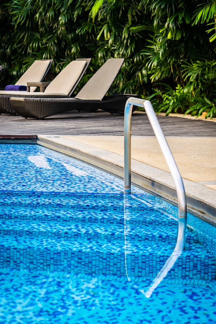 Foto grátis bela piscina ao ar livre com cadeira de cama e guarda-chuva em resort para viagens e férias